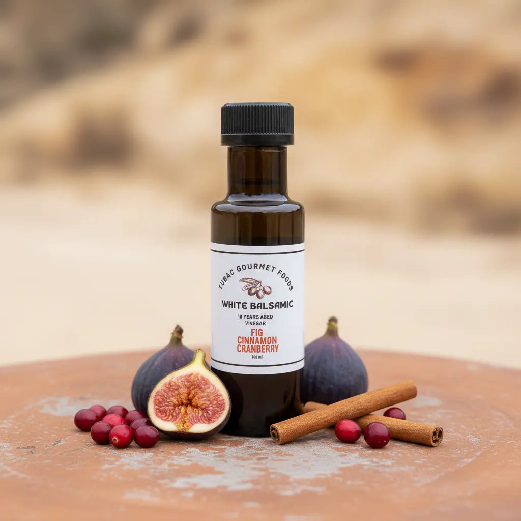 Fig Cinnamon Cranberry White Balsamic Vinegar bottle with figs, cranberries and cinnamon on terracotta surface