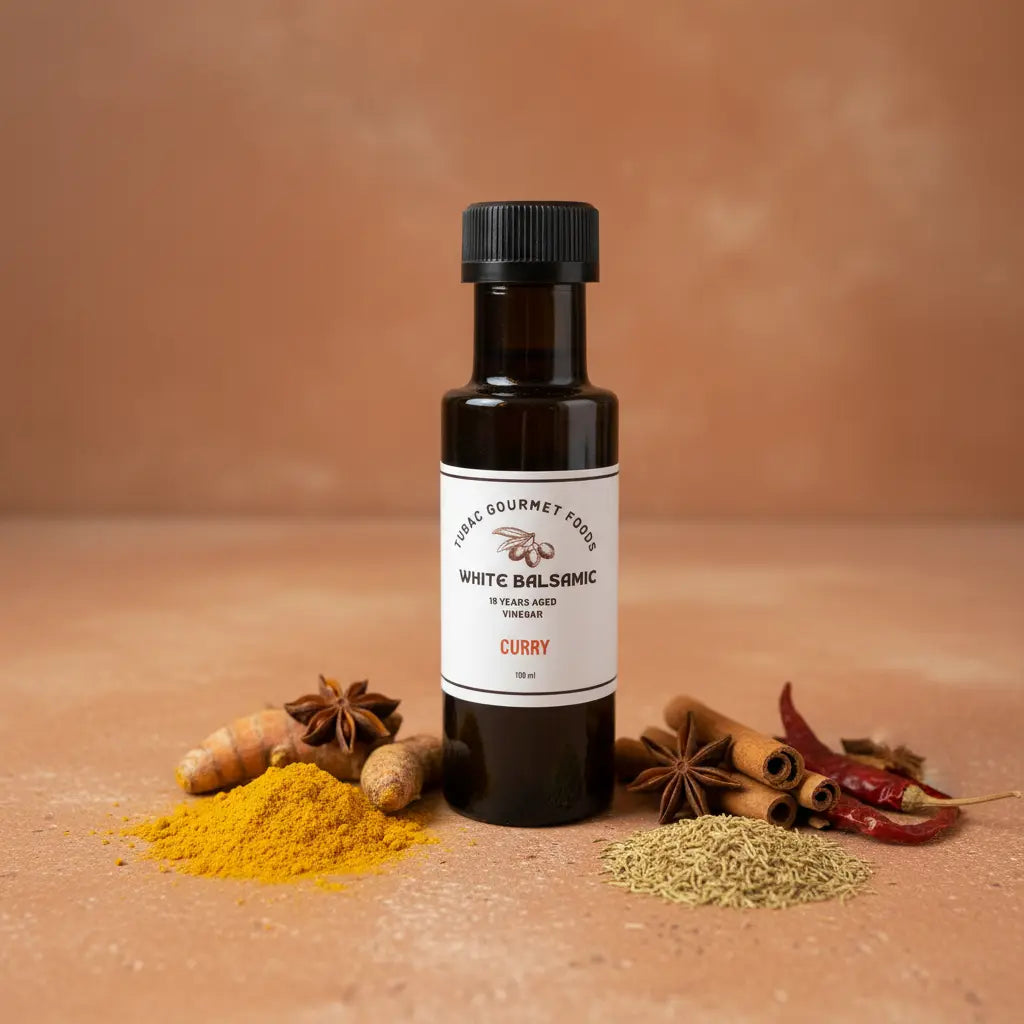 Curry White Balsamic Vinegar bottle with curry spices on terracotta surface