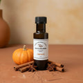 Pumpkin Pie White Balsamic Vinegar bottle with pumpkin and cinnamon sticks on terracotta surface